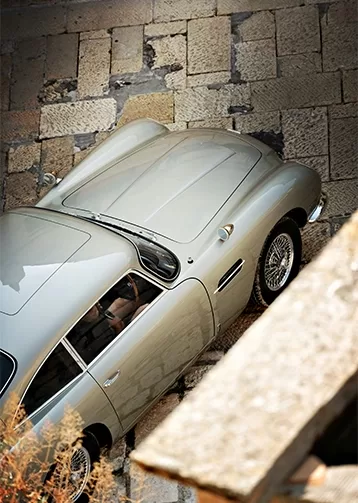An above shot of a silver luxurious car parked in a drive.