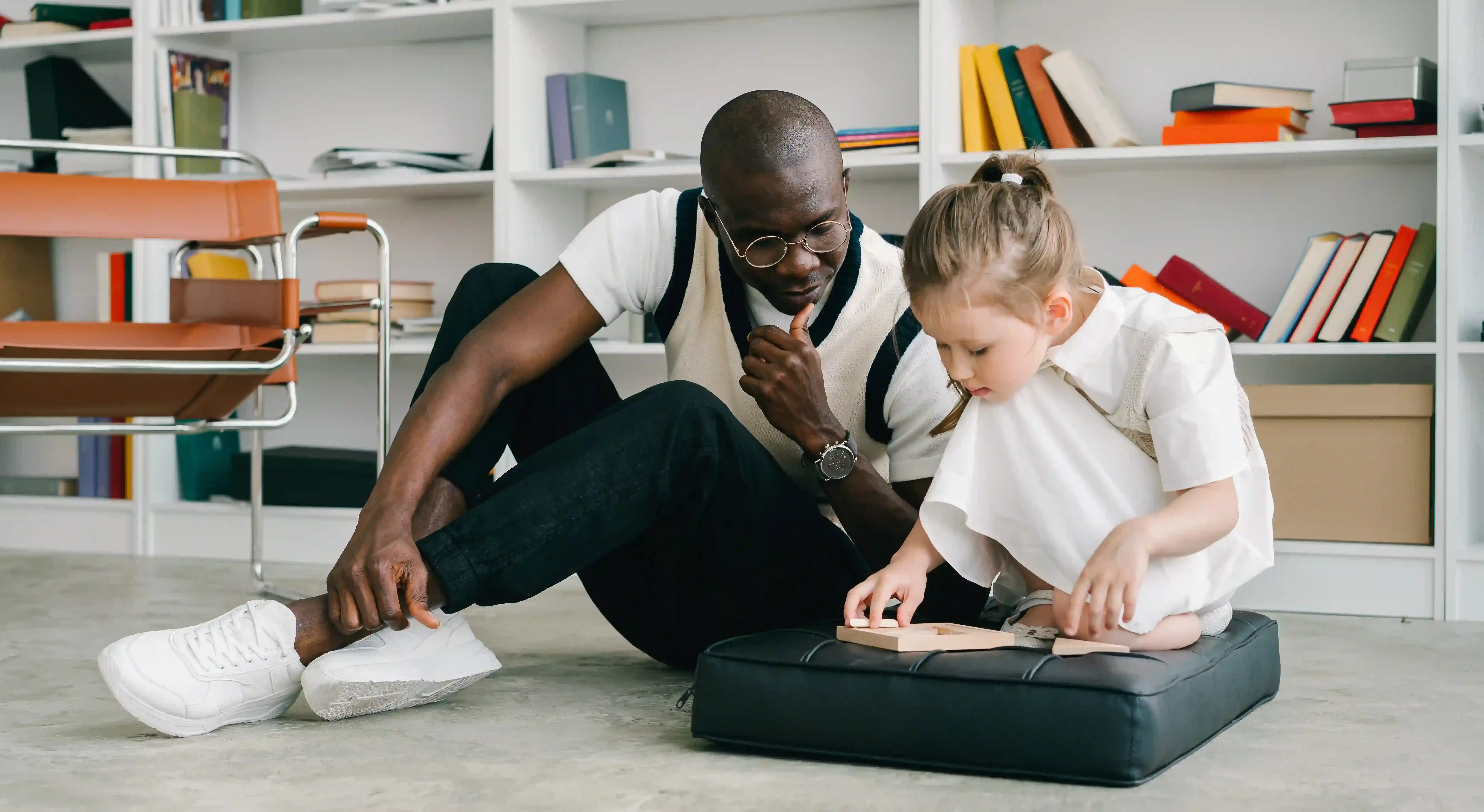 Psychologists doctor sat on floor with child reading a book