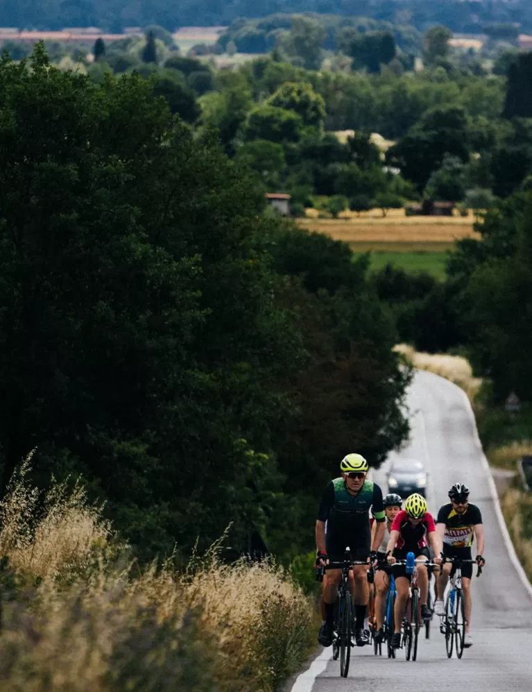 Quintessentially Foundation | group of people cycling down round