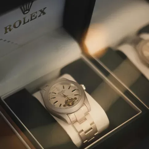 A silver Rolex in an opened white beautiful Rolex box.
