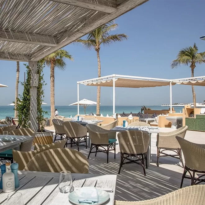 Beach side restaurant with set wicker tables overlooking the seafront.