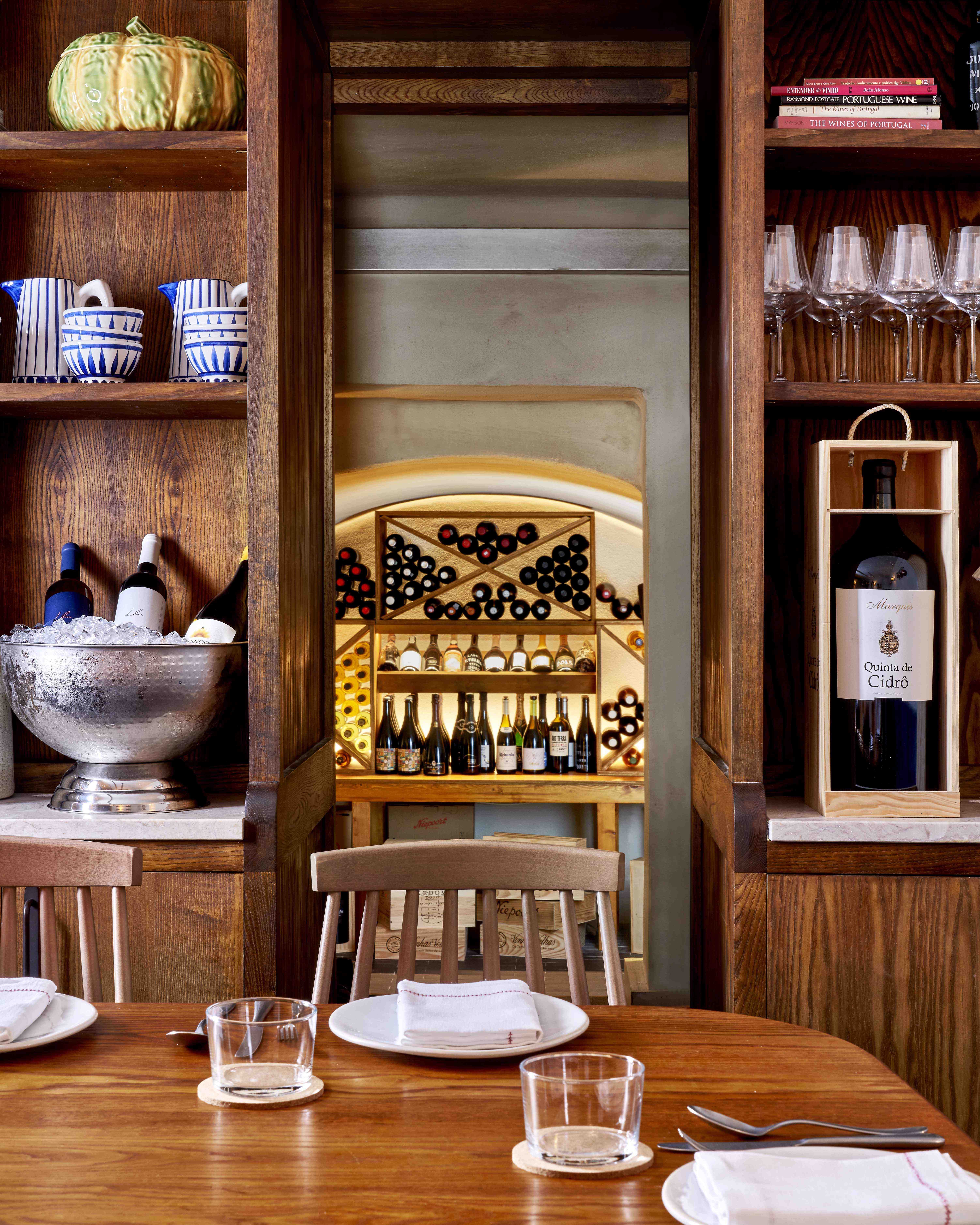 Dining table set up in front of wine shelves and wine cellar
