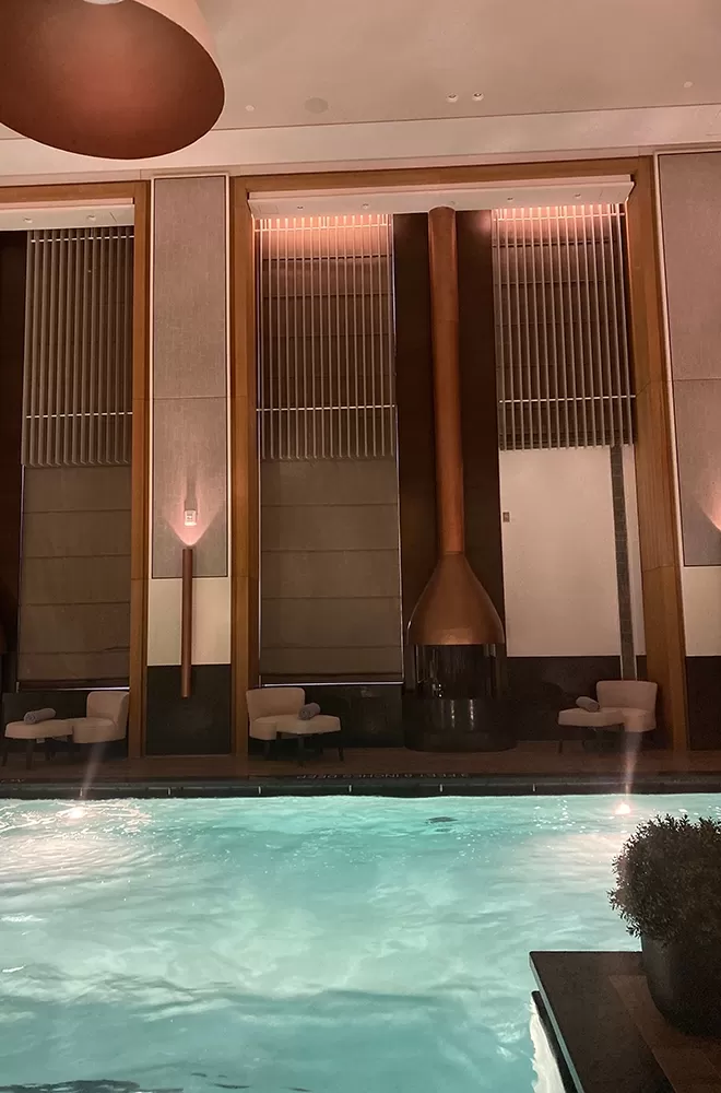 Luxury lit up pool with poolside lounge chairs at Aman Spa, New York