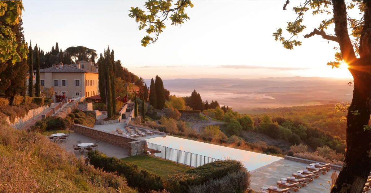 Infinity pool between the hills overlooking sunset, clouds and mountains at Castiaglion di Bosco hotel