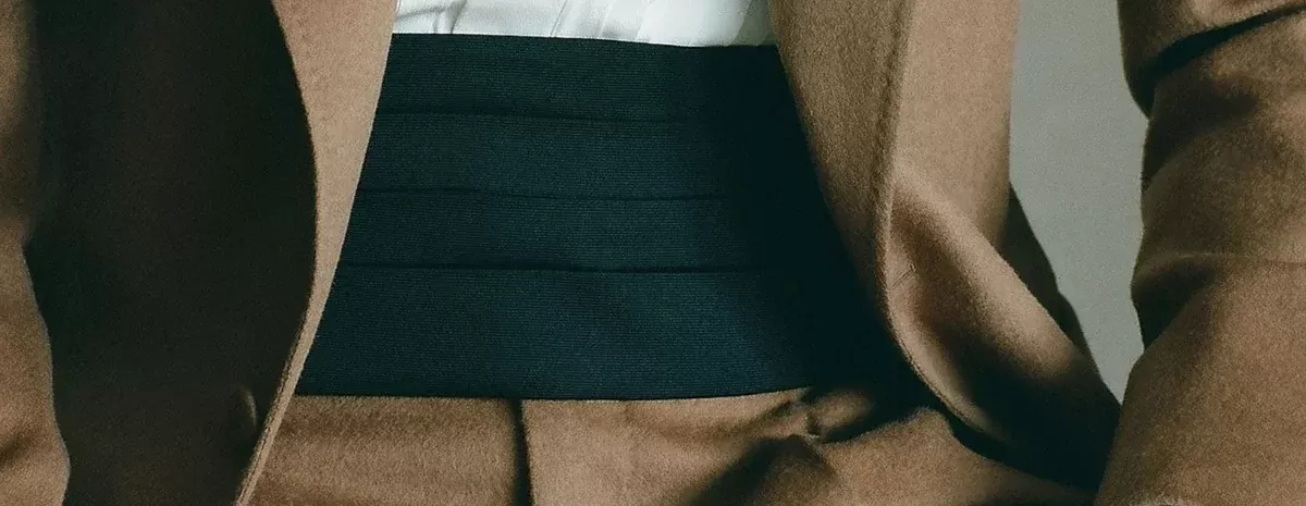 Plain black cummerbund with a beige suit