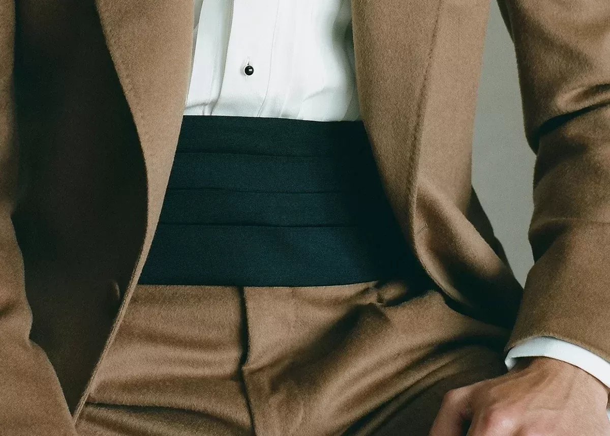Plain black cummerbund with a beige suit