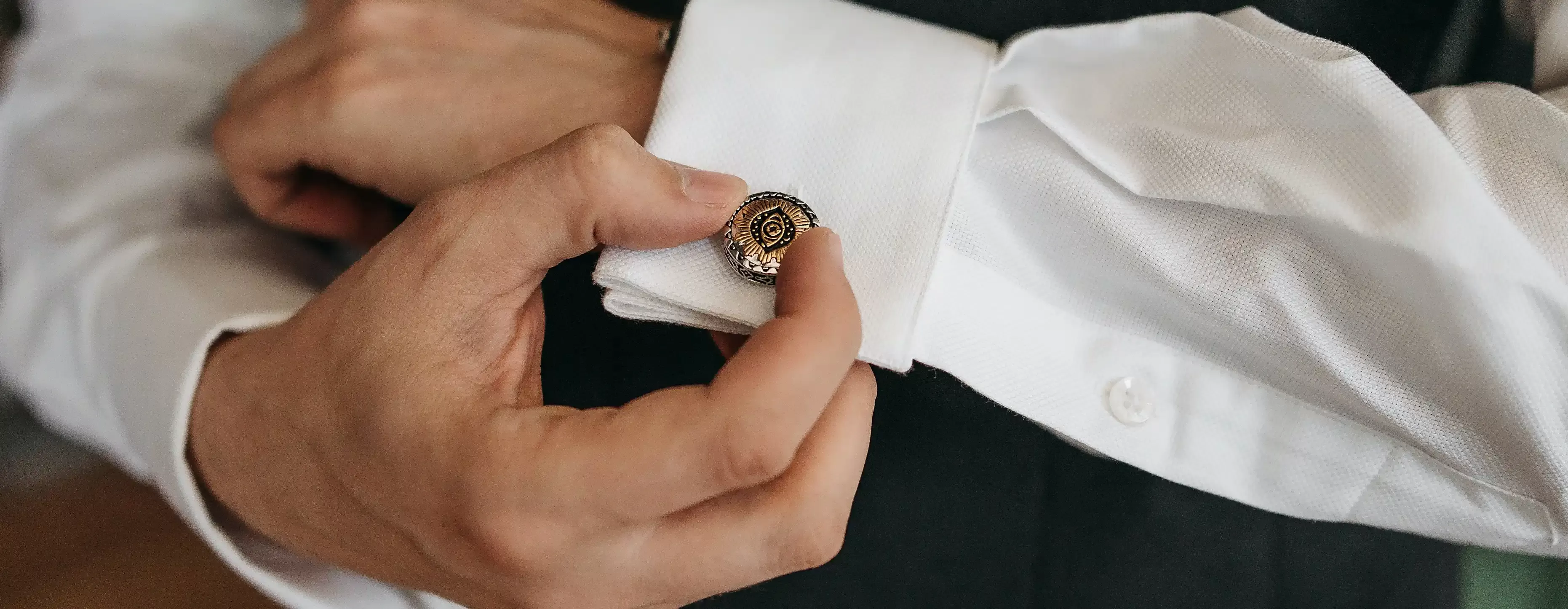 Antique medallion style cufflinks on a whit shirt