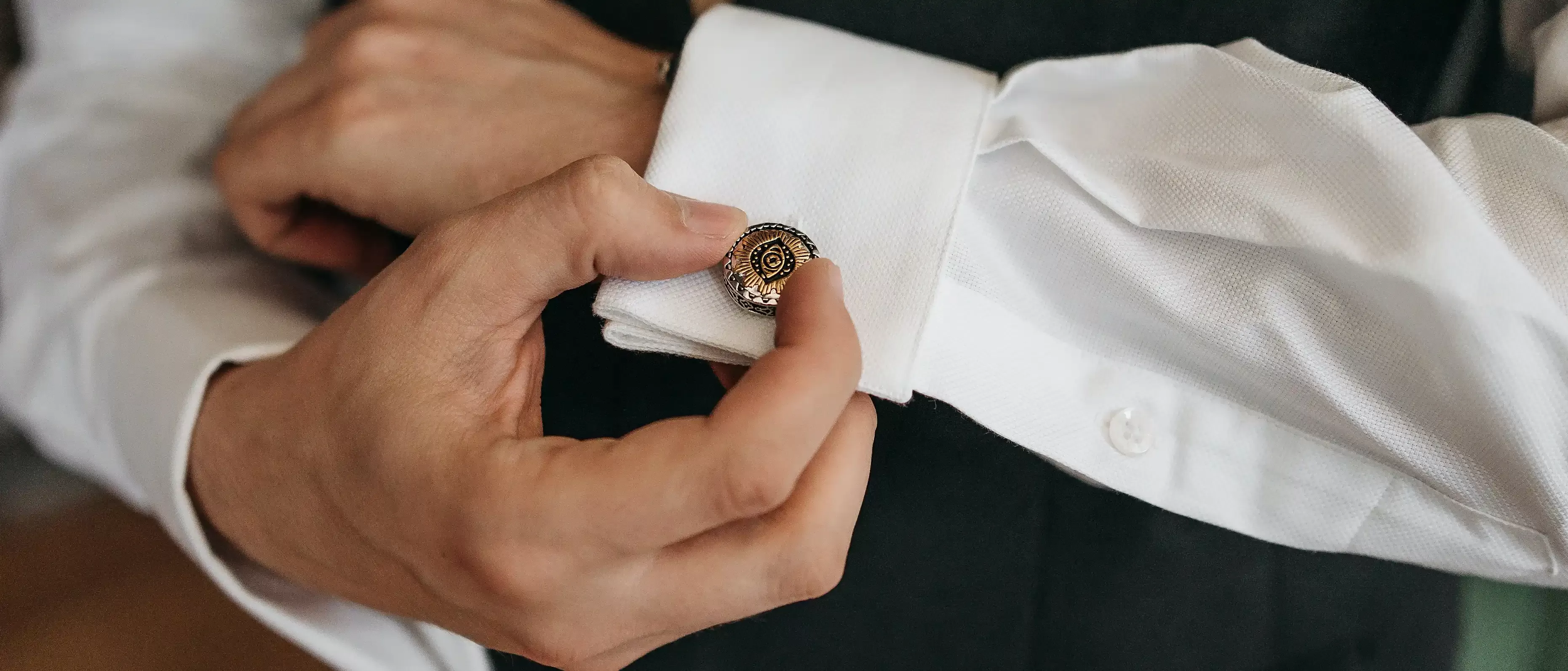Antique medallion style cufflinks on a whit shirt