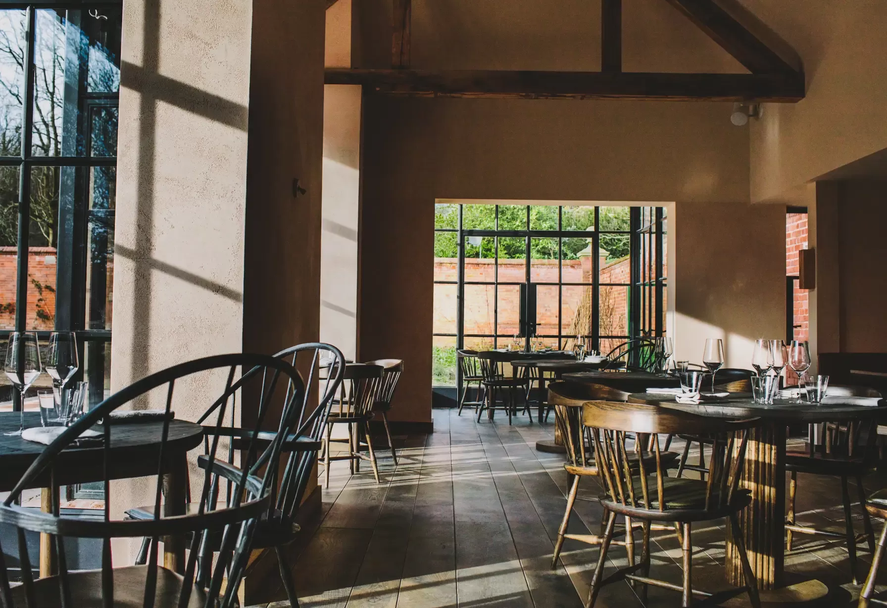 Airy restaurant interior with glass windows to rural view at Grace & Savour
