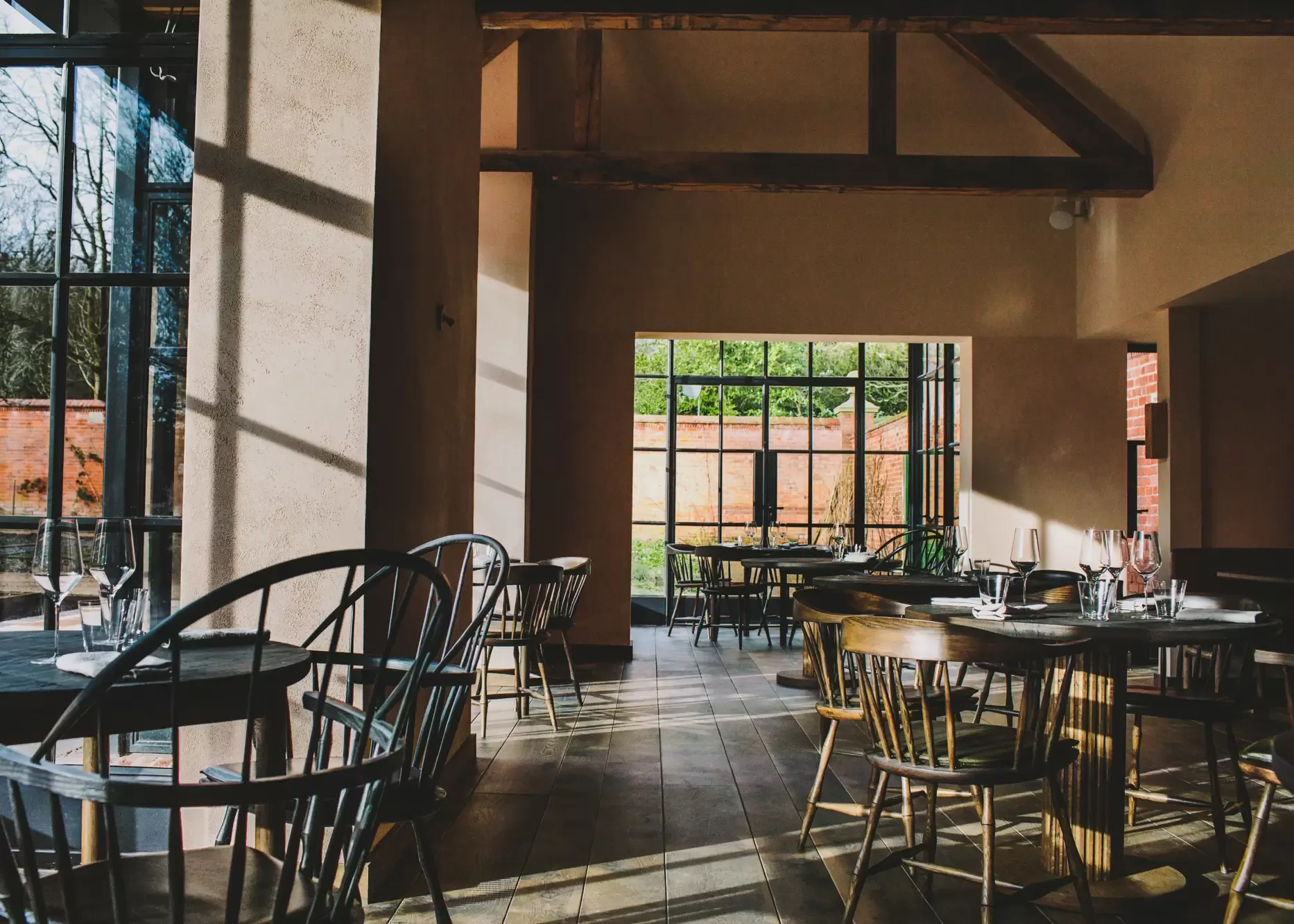 Airy restaurant interior with glass windows to rural view at Grace & Savour