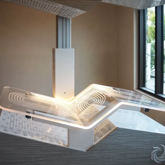 A modern, transparent hospital bed with illuminated edges and geometric patterns, positioned near a window with natural light streaming in.