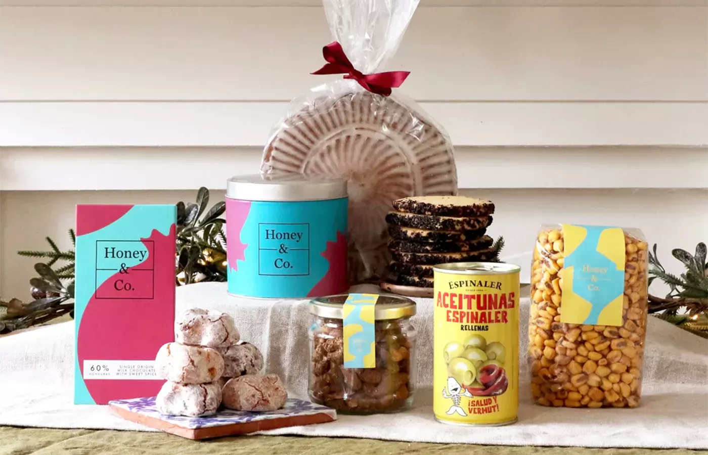 Food and drink laid out on the table surrounded by Honey Co House Party Hamper