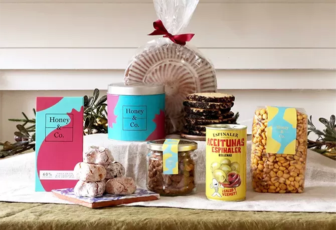 Food and drink laid out on the table surrounded by Honey Co House Party Hamper