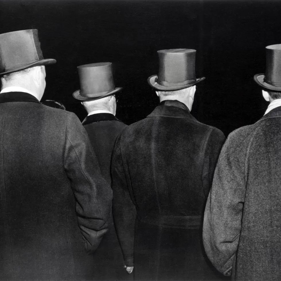 Black and white photo of men wearing formalwear opera hats