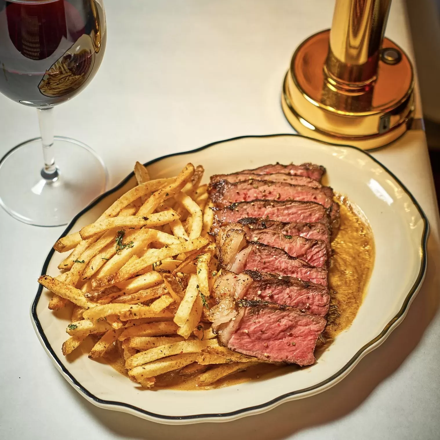 Steak and fries served on large oval plate at Petite Patate Prospect Heights, Brooklyn, USA