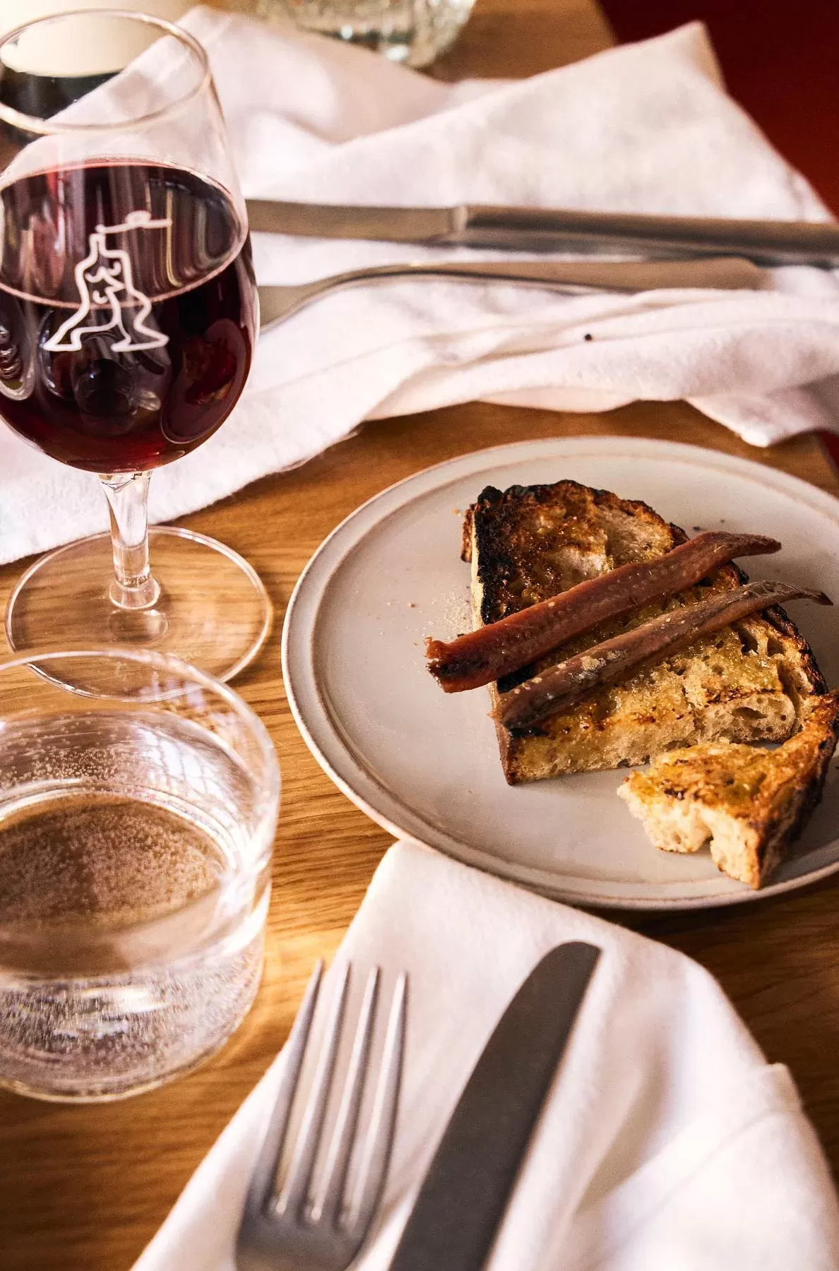 Sardine toast with butter served with wine on a table at Place des Fêtes, Clinton Hill, Brooklyn, USA
