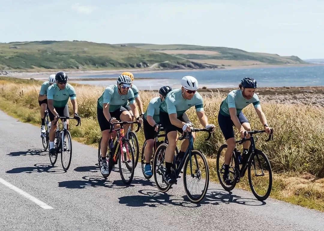 Group of cyclists cycling on road next landscape and sea view on 'led by leaders' cycling exhibition by Le Blanq in Norway