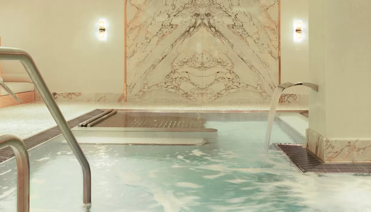 Luxury indoor spa pool with water fountain and spray jets at Spa Diane Barrière, New York