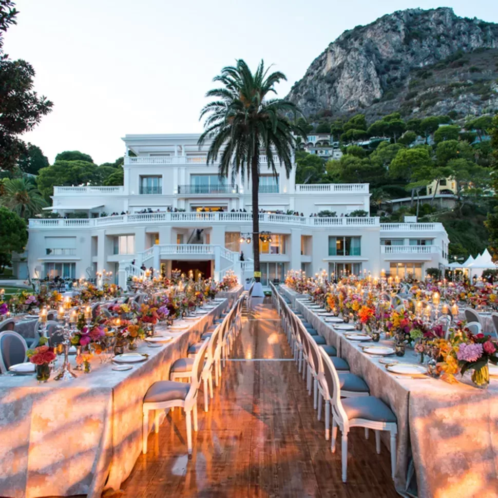 A beautifully decorated wedding reception at a villa in Capri, featuring elegant tables and floral arrangements under soft lighting.
