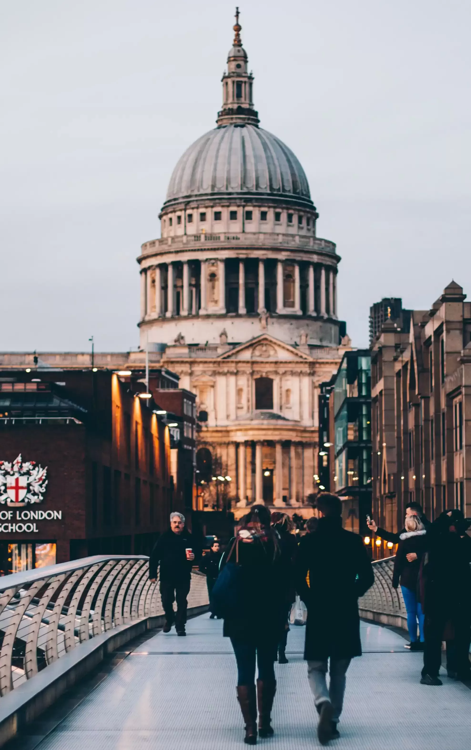 People walking across bridge in London towards St. Pauls Cathedral
