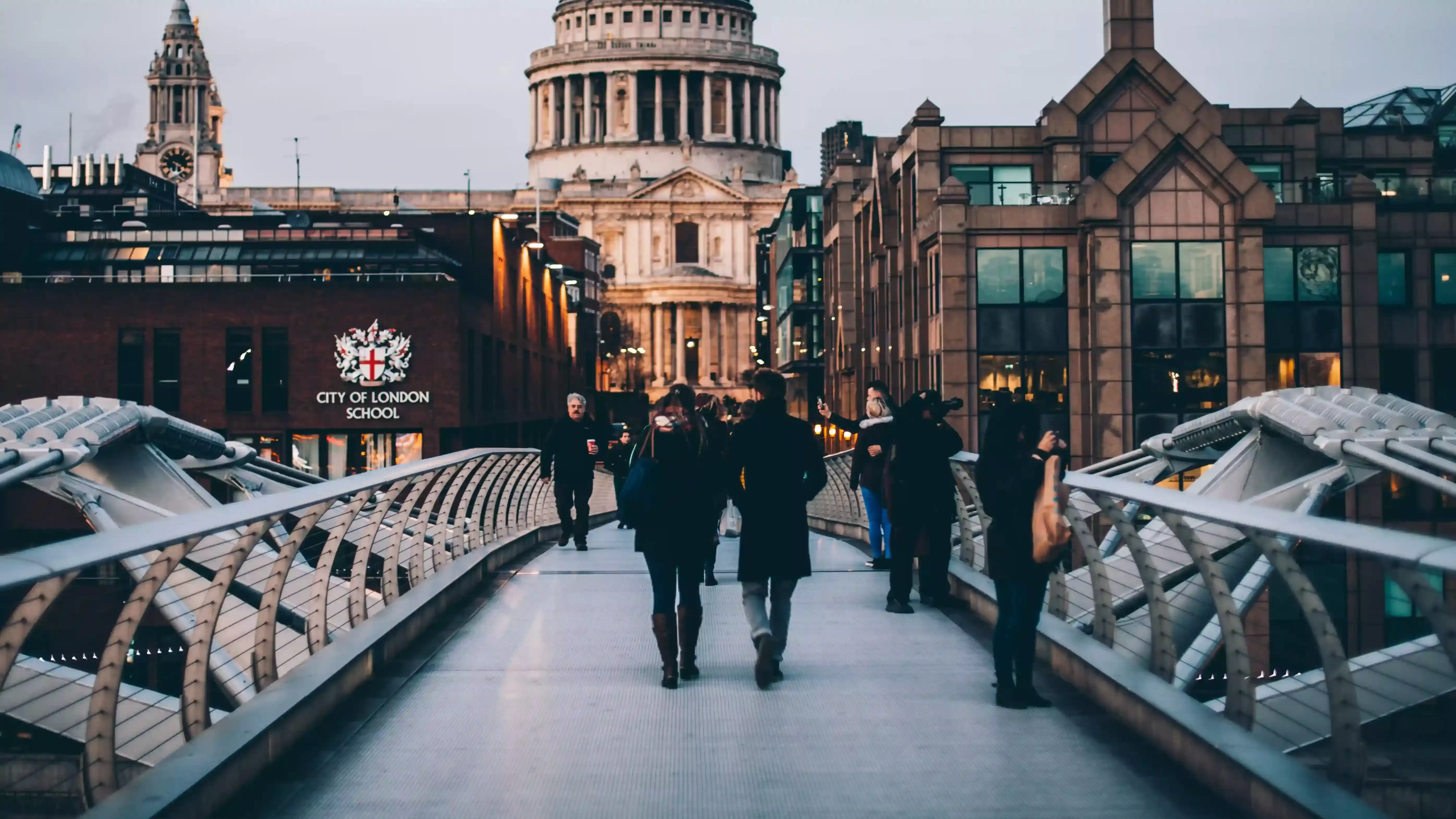 People walking across bridge in London towards St. Pauls Cathedral
