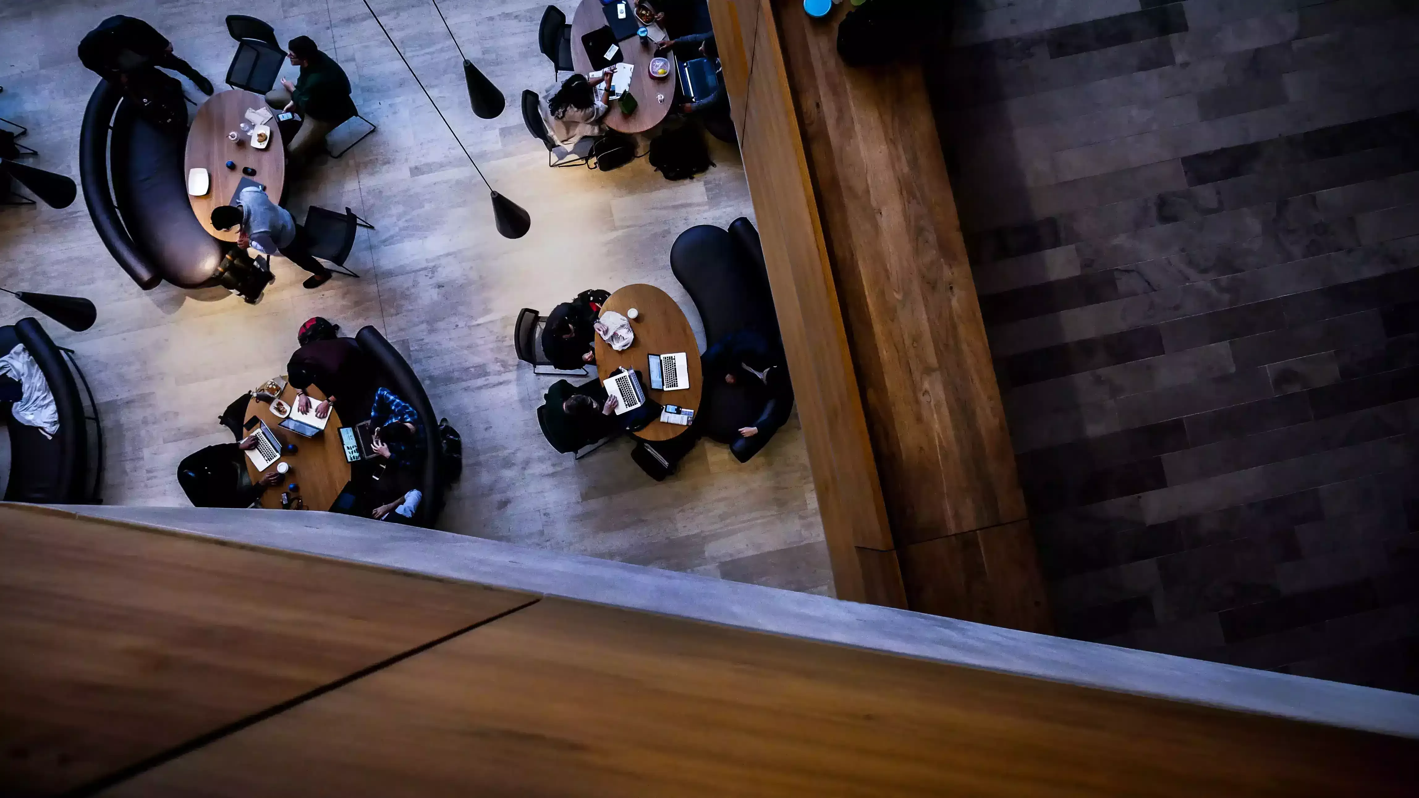 Birdseye view of people sat at round tables in a library