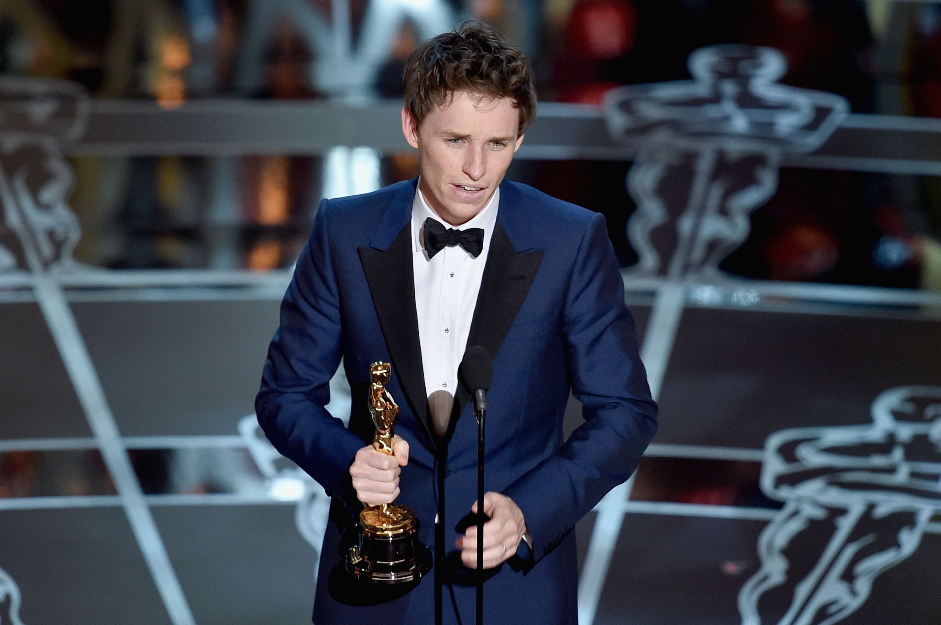 Eddie Redmayne in a blue tuxedo accepting his Oscar in 2015